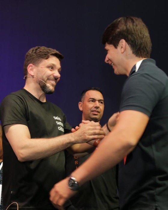 Edvan Jacques recebendo um prêmio no palco de um evento de lançamento